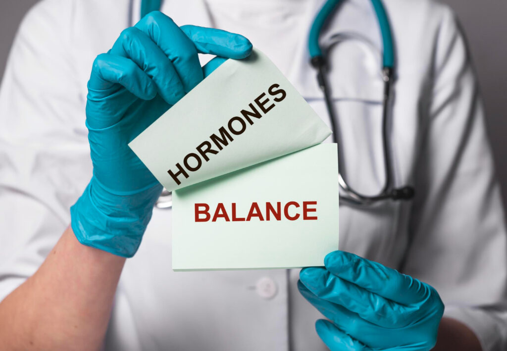 A doctor holding written paper note with Hormones balance printed on it